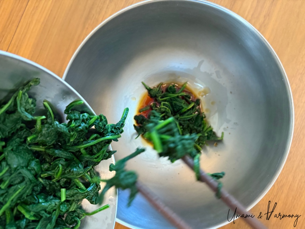 Spinach added to the bowl of dressing
