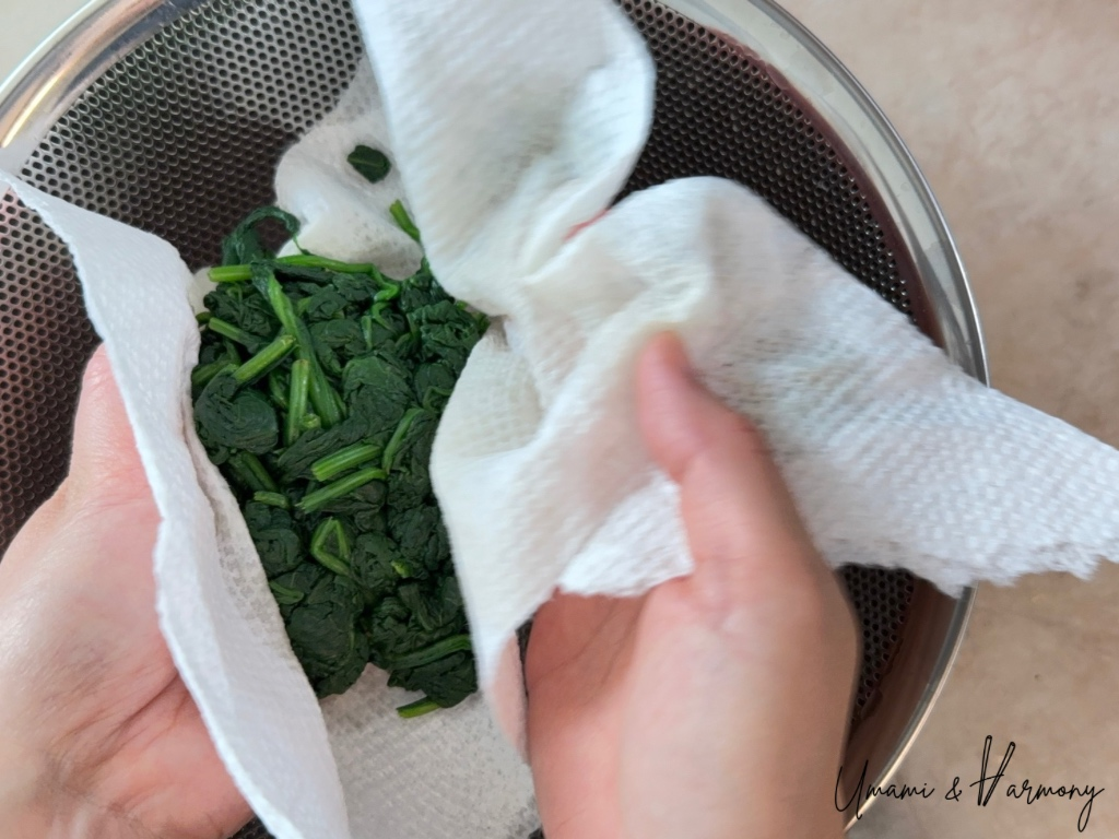 Spinach wrapped in kitchen paper to gently squeeze out excess water