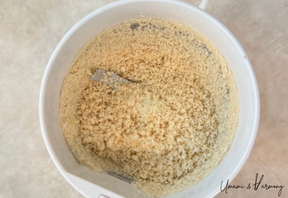 Crushed peanuts in a food grinder after processing.