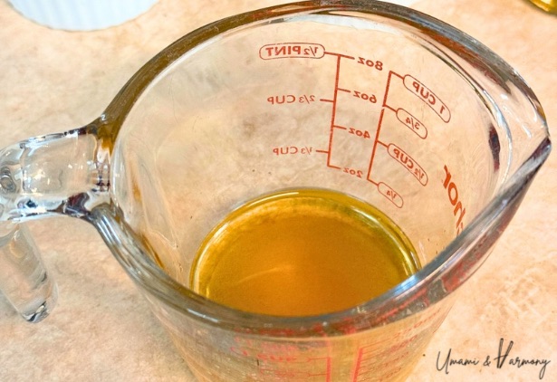 Sugar, vinegar, and soy sauce in a glass measuring cup