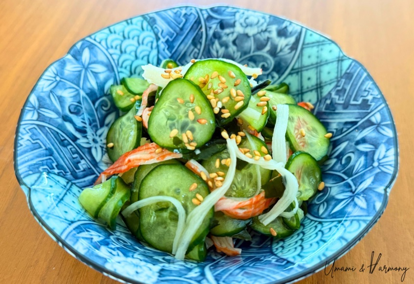Japanese cucumber and wakame salad (sunomono) topped with shredded imitation crab meat (surimi), served in a small bowl