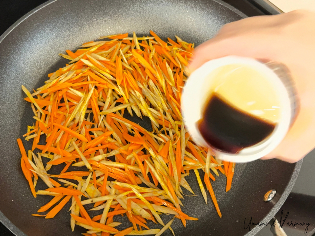 Soy sauce added to Kinpira Gobo in the pan
