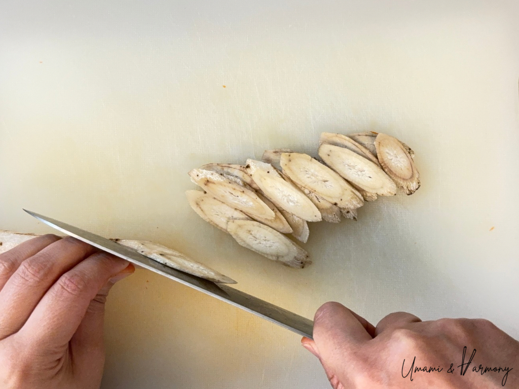 Burdock root peeled and sliced thinly on a cutting board