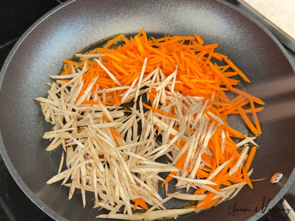 Carrots and burdock root stir-fried together in a pan