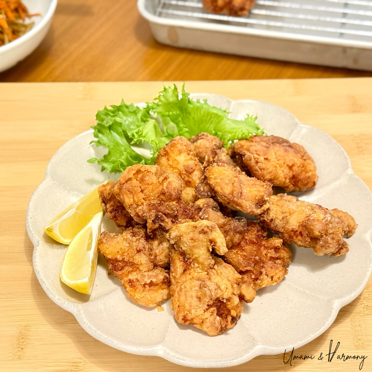 Crispy Japanese karaage chicken served on a plate with lemon wedges and greens