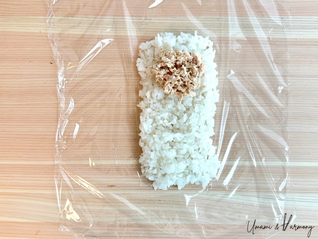 Tuna mixture placed on the top half of the rice rectangle.