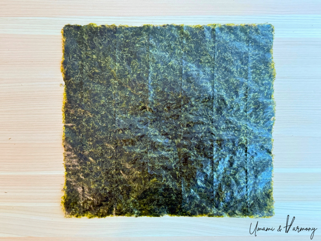 A full-sized sheet of nori seaweed before cutting.