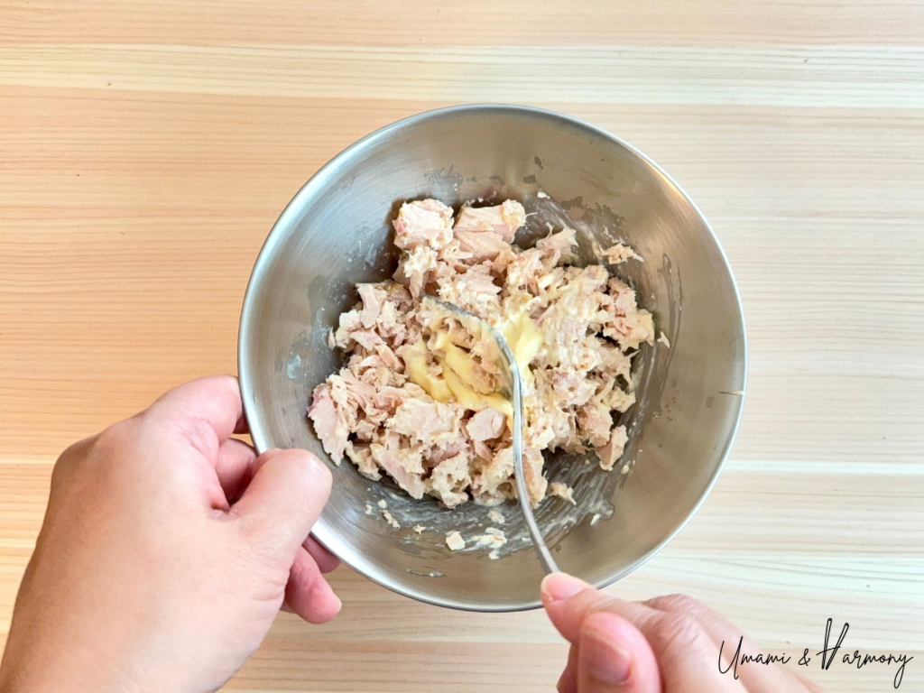 Tuna mixed with mayonnaise in a small bowl.