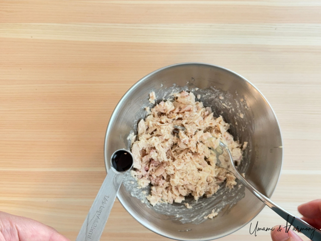Soy sauce being added to the bowl of tuna and mayo.