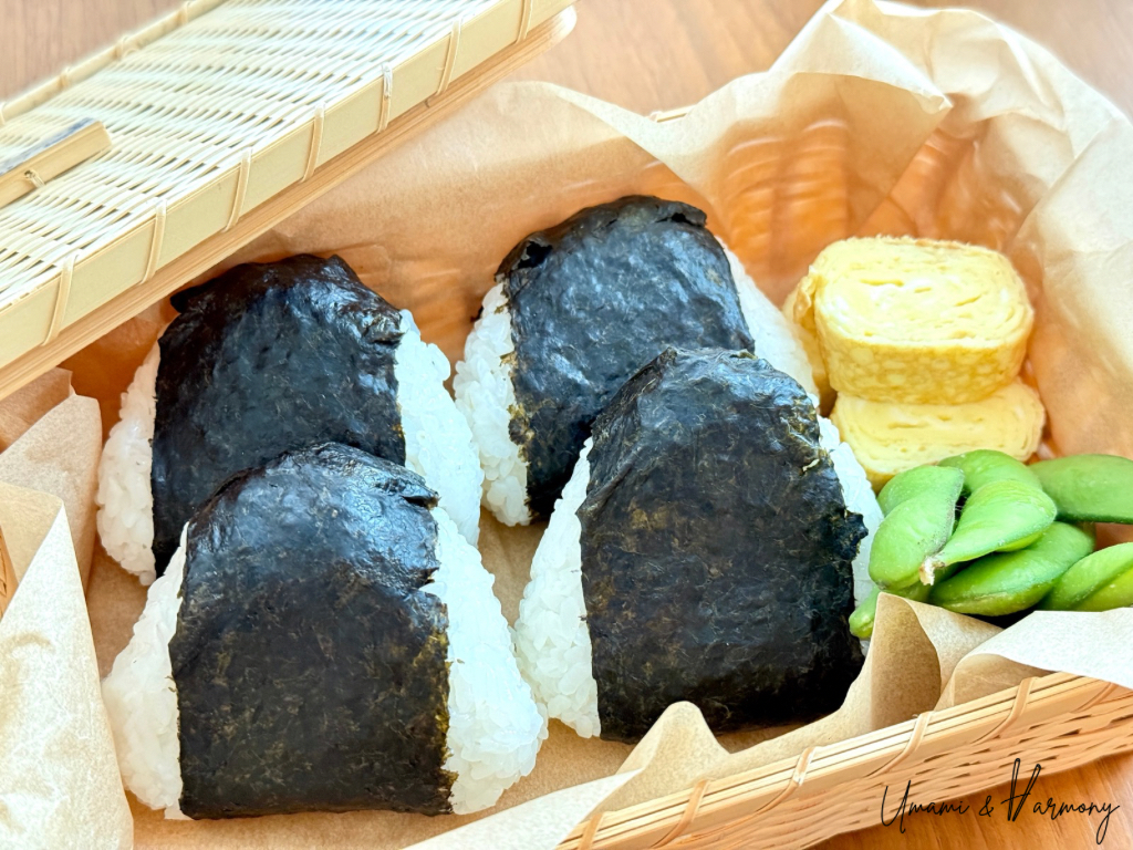 Tuna mayo onigiri arranged in a bamboo rattan box.