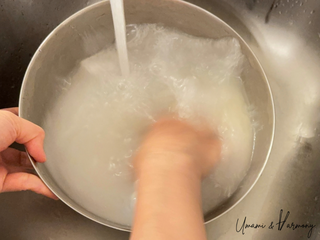 Swirling sushi rice with added water for rinsing