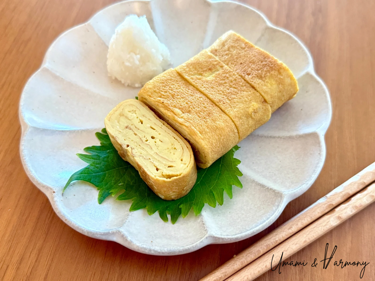 Finished tamagoyaki slices served with grated daikon radish and a Shiso leave