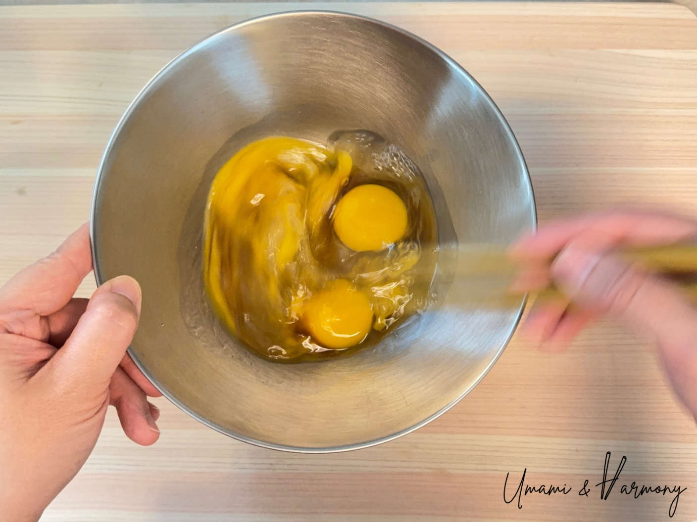 Eggs being whisked with chopsticks for tamagoyaki