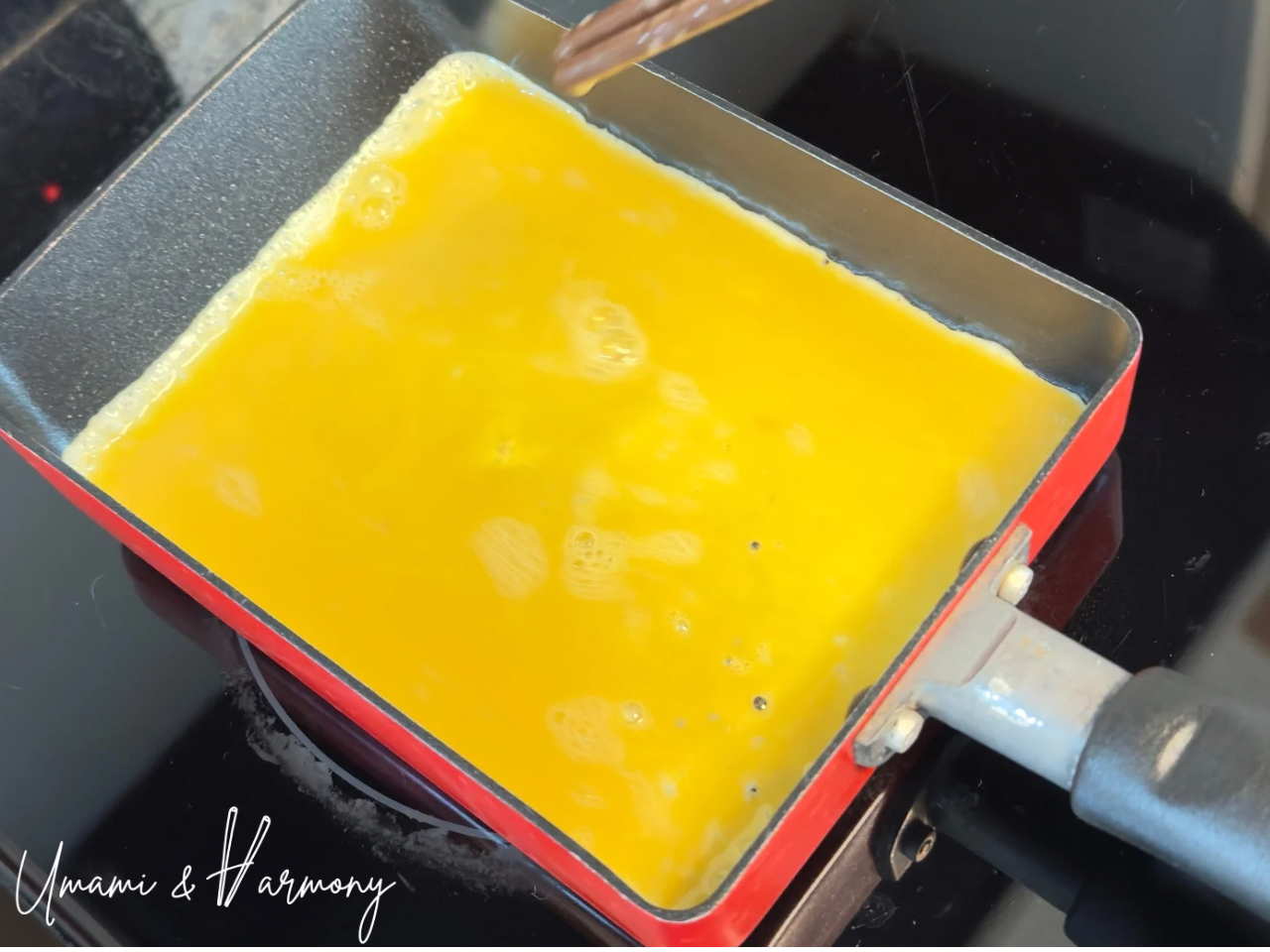 Egg mixture spread evenly in a tamagoyaki pan