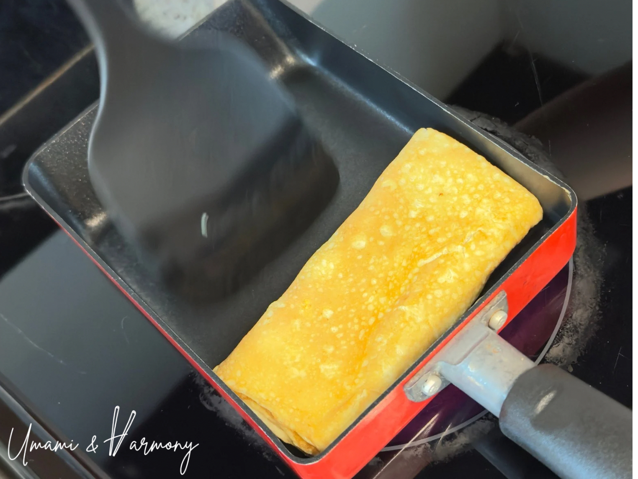 Tamagoyaki second layer fully rolled with spatula