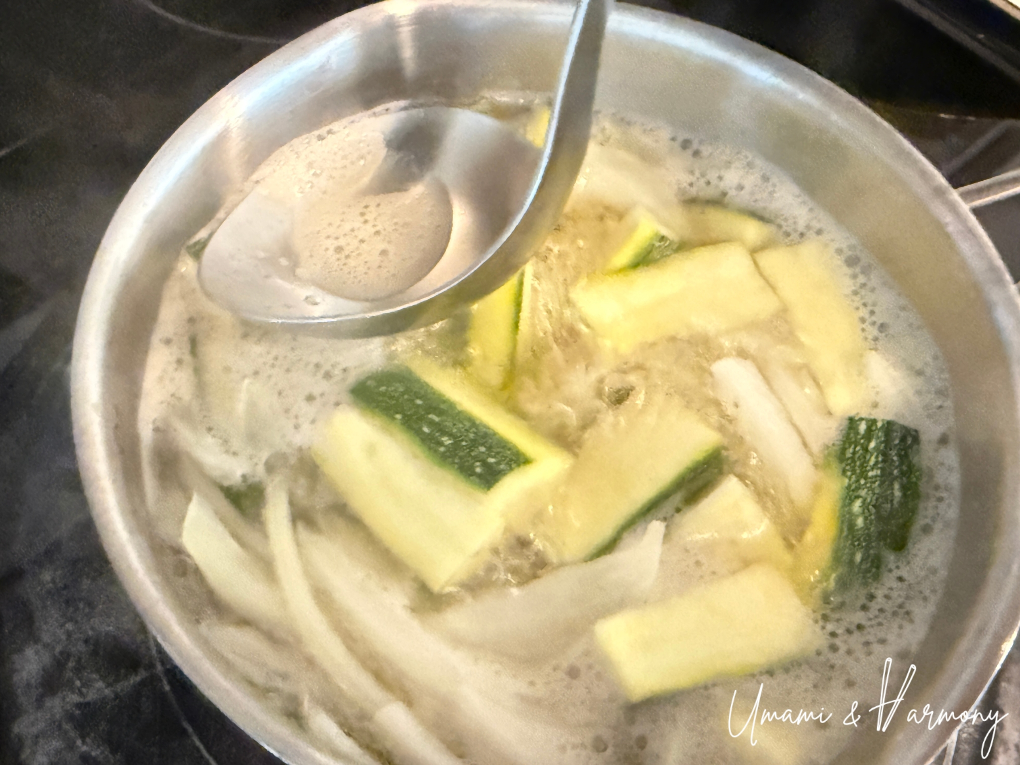 Skimming off foam from simmering vegetables in broth