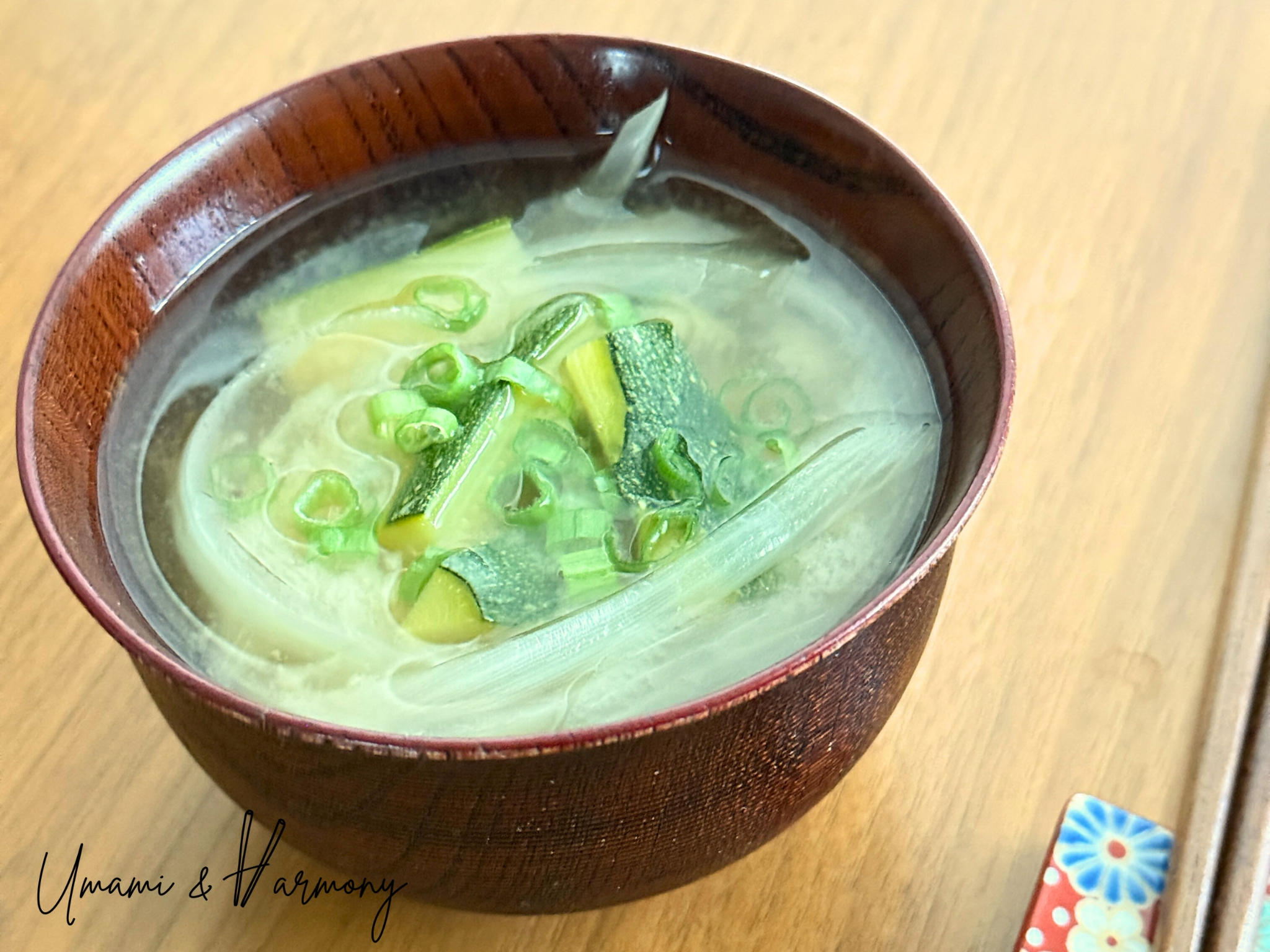Finished zucchini miso soup served in an owan bowl with chopped green onion garnish