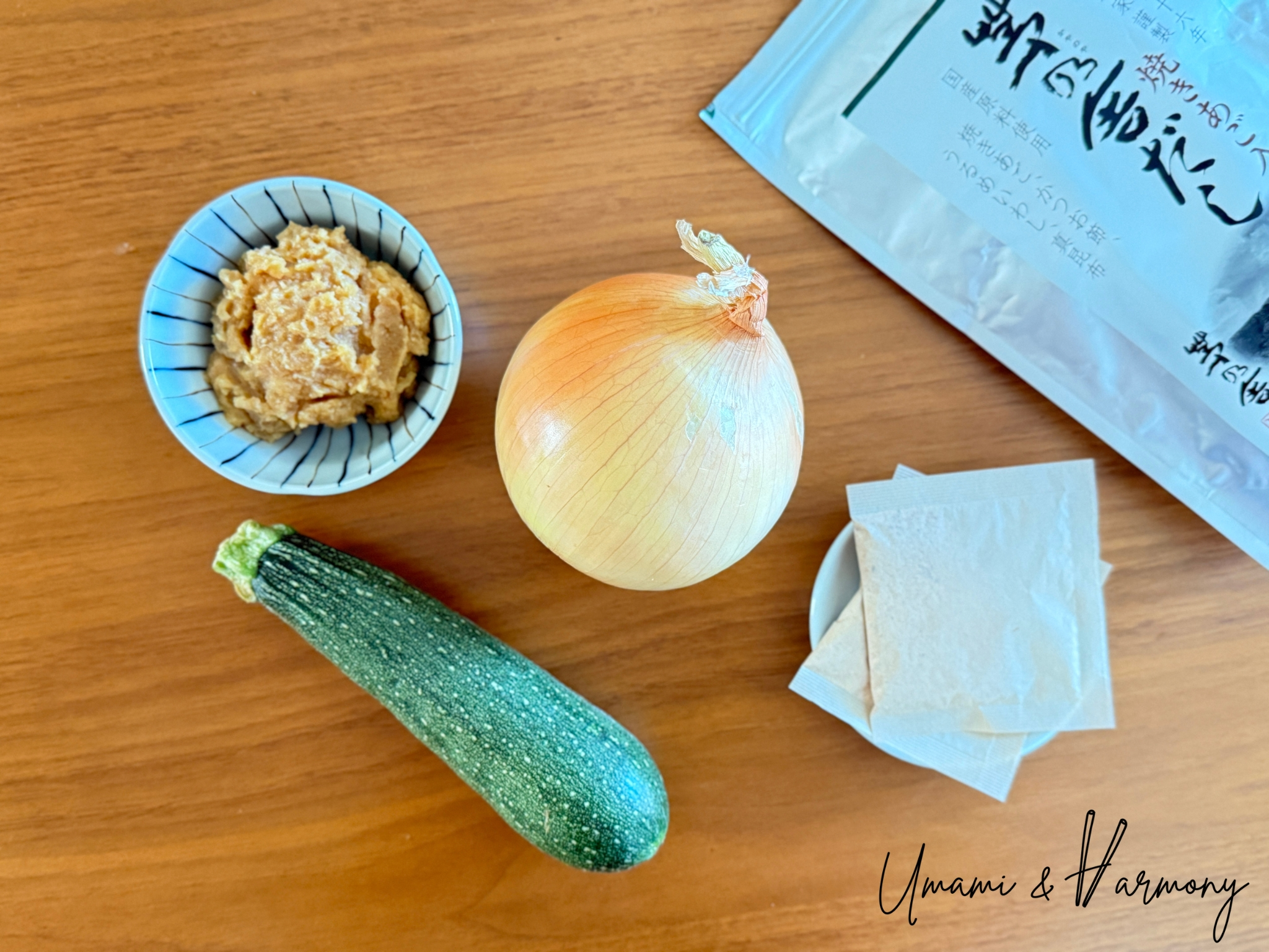 Ingredients for zucchini miso soup: miso paste, zucchini, onion, and dashi packs
