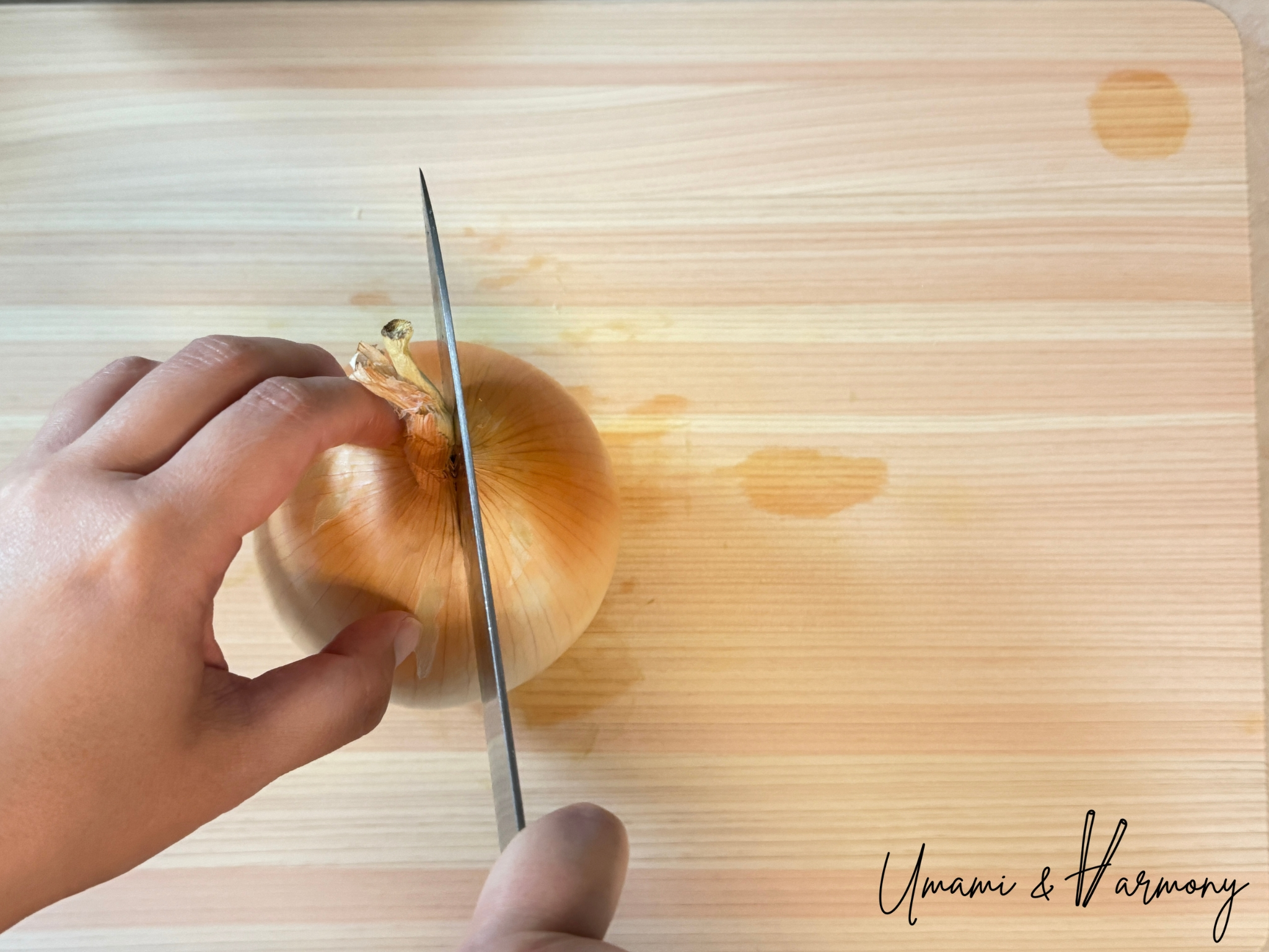 Cutting onion in half on a cutting board