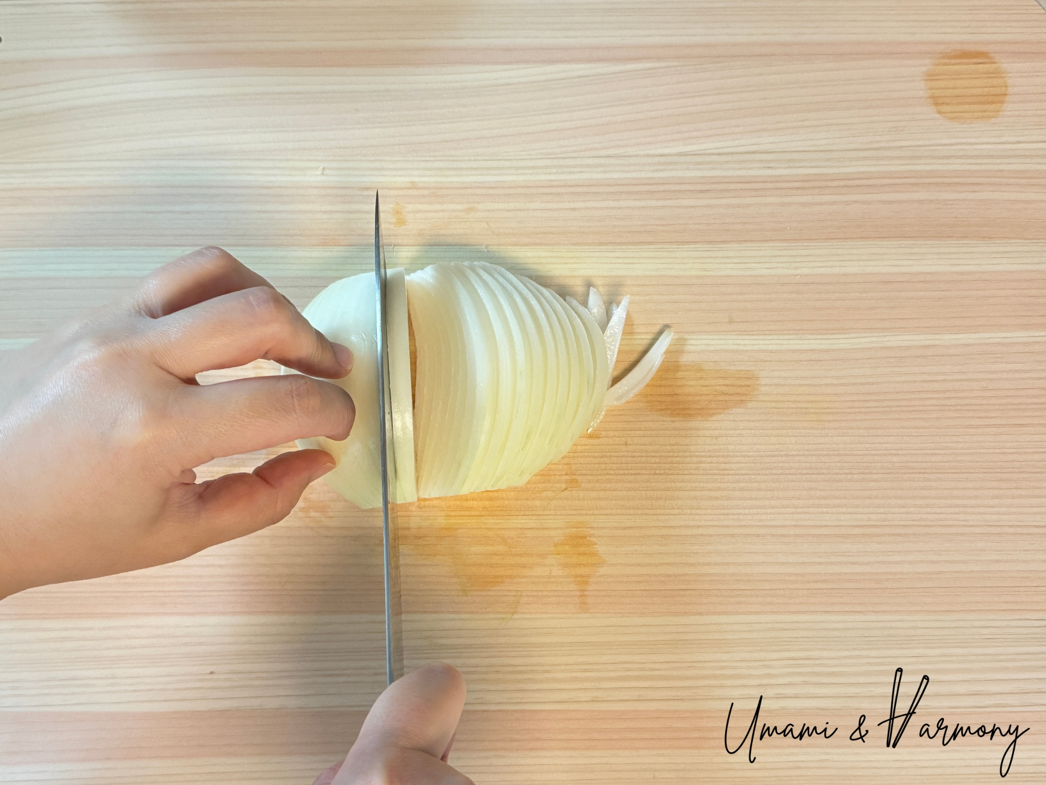 Slicing onion thinly with a kitchen knife