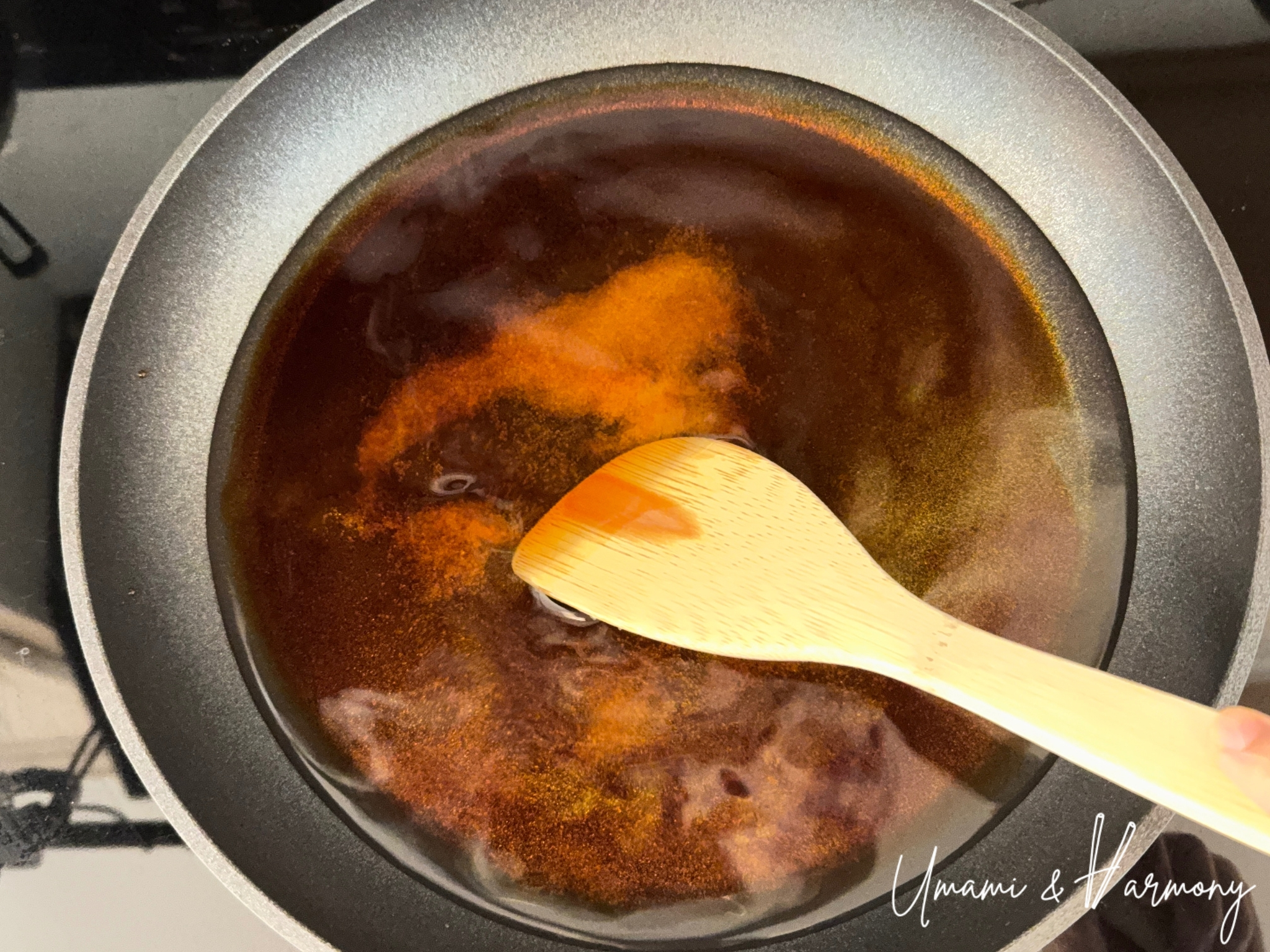 Mixing Gyudon sauce ingredients with a spatula in a skillet