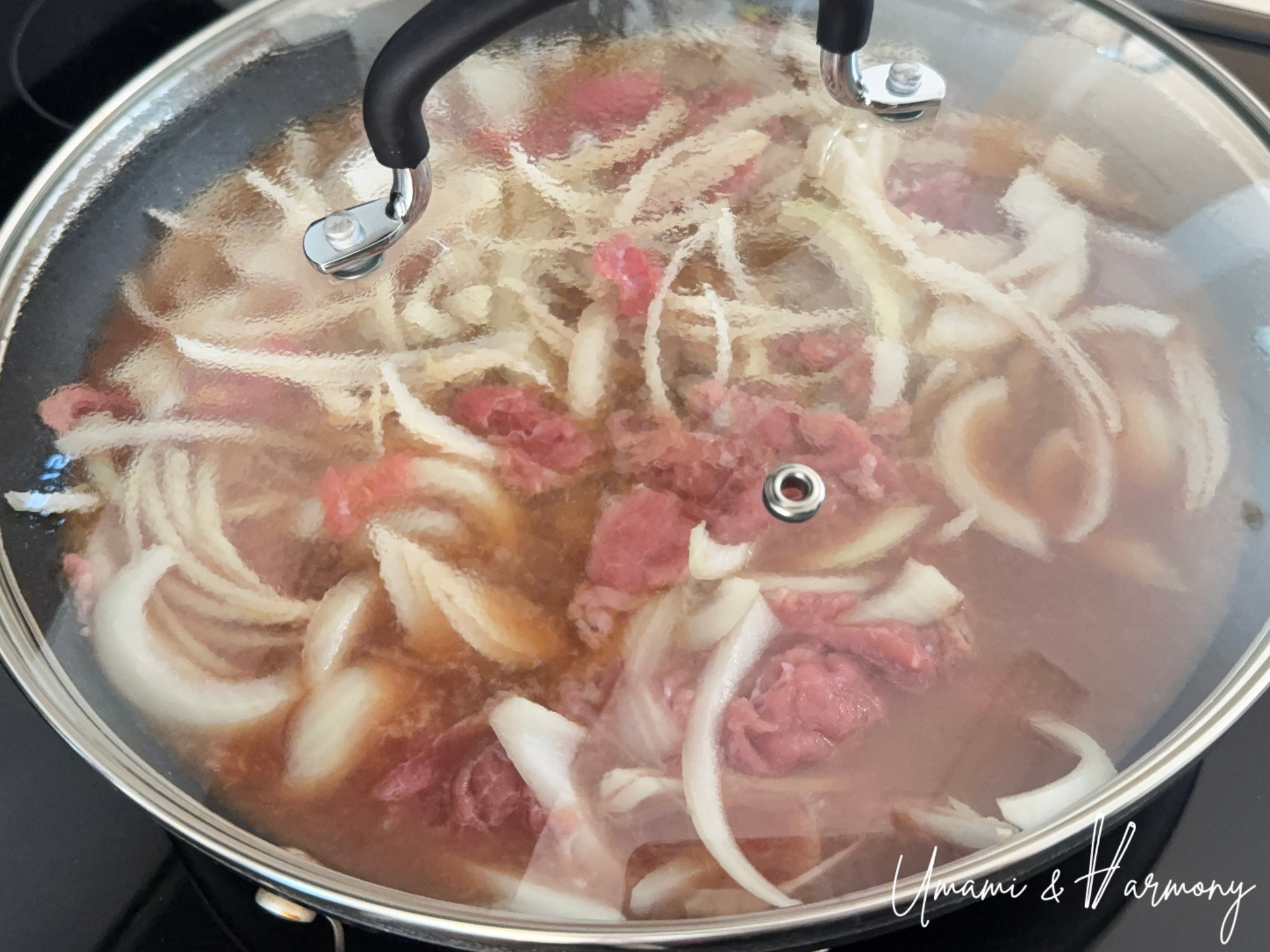 Covering the skillet with a lid to simmer Gyudon