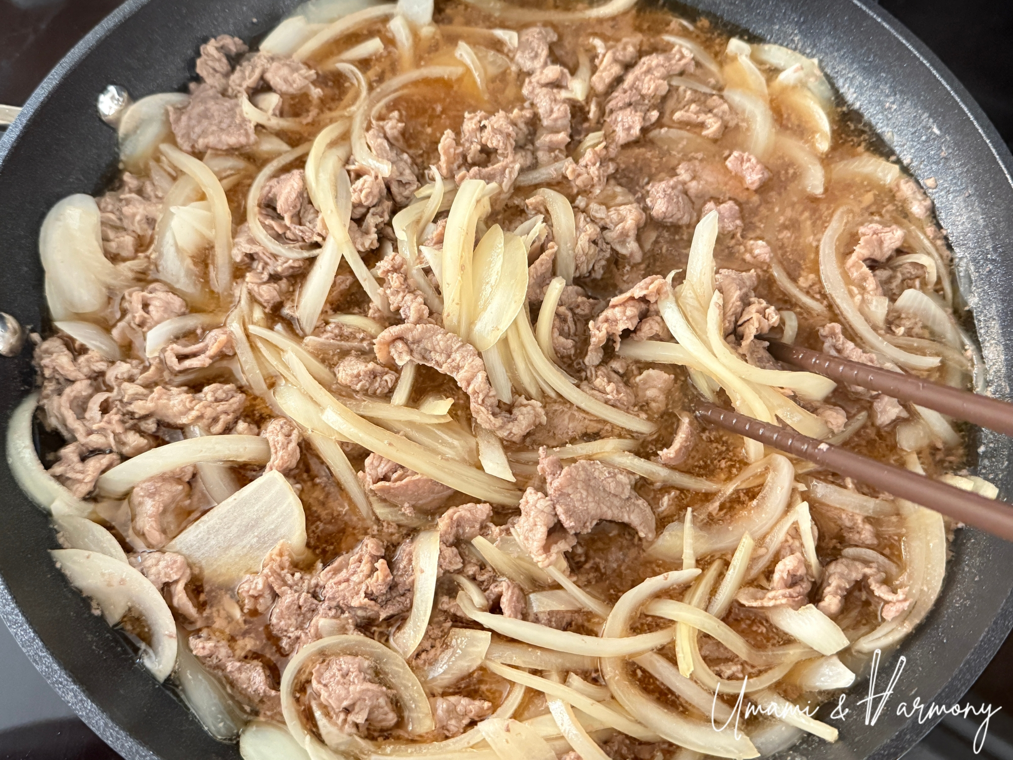 Cooking beef and onion in a sweet-savory sauce until tender