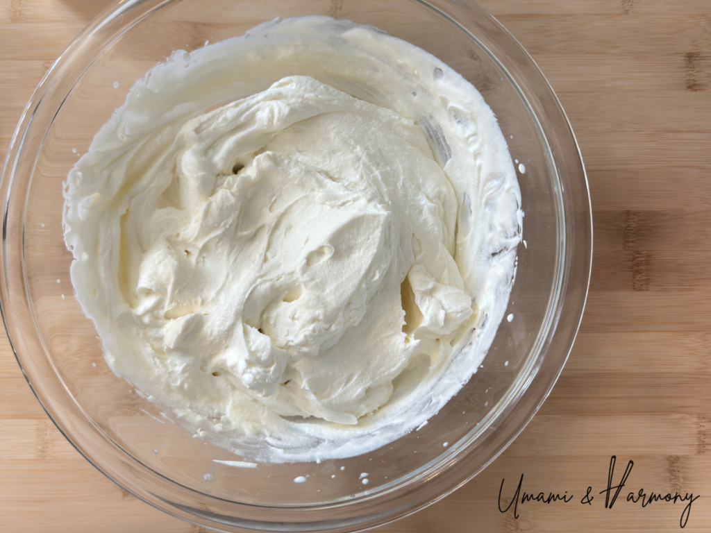 Combining whipped cream and mascarpone cheese until smooth