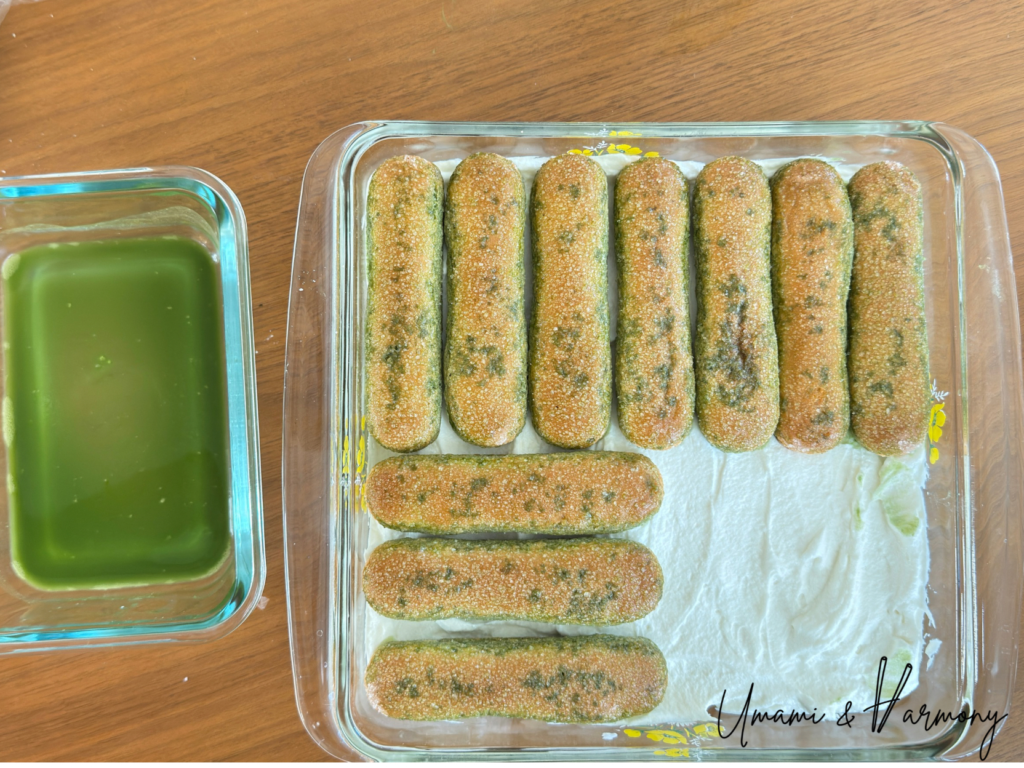 Adding second layer of matcha-dipped ladyfingers to the tiramisu