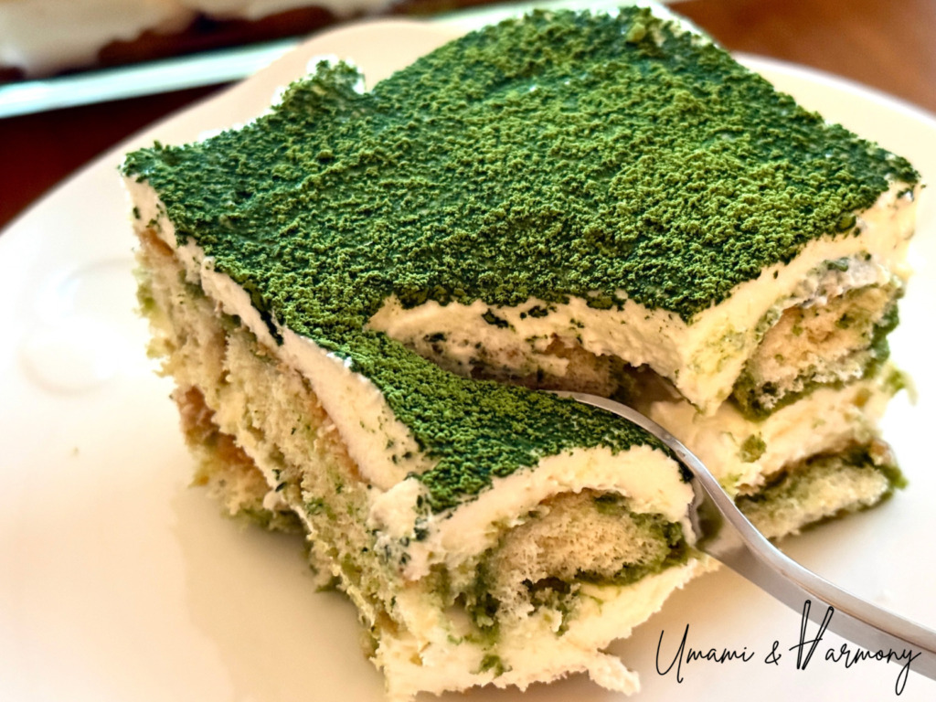 Scooping a piece of Matcha Tiramisu with a fork showing its creamy layers