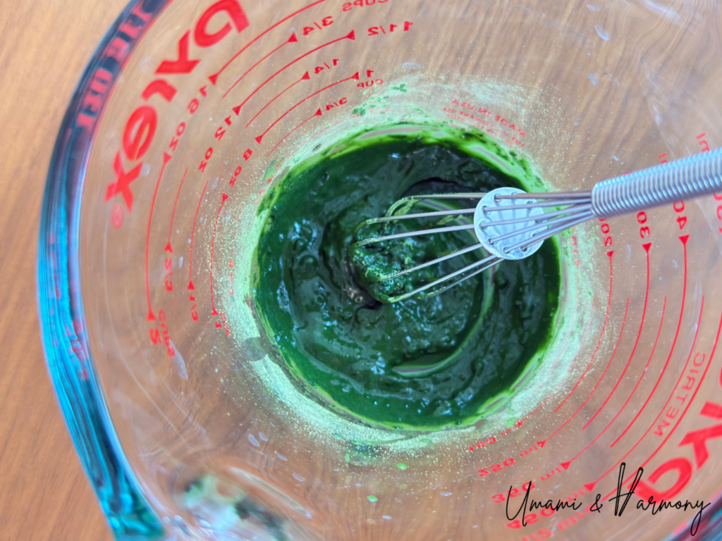 Mixing matcha powder with a small amount of hot water to form a smooth paste