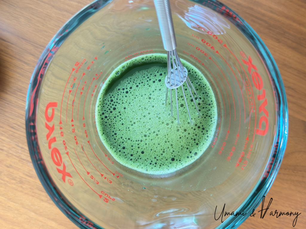 Matcha powder fully dissolved in hot water creating smooth liquid without lumps