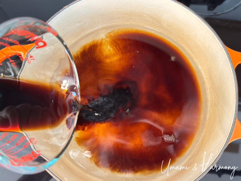 Pouring Nikujaga seasoning into a dutch oven