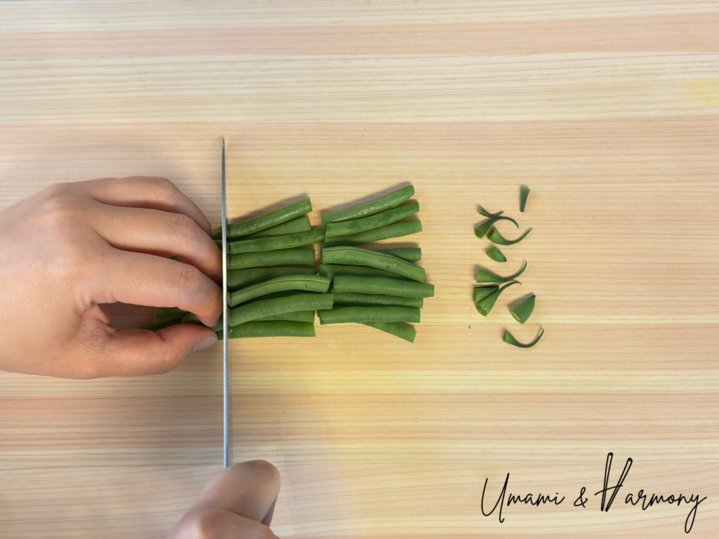 Cutting green beans on a cutting board