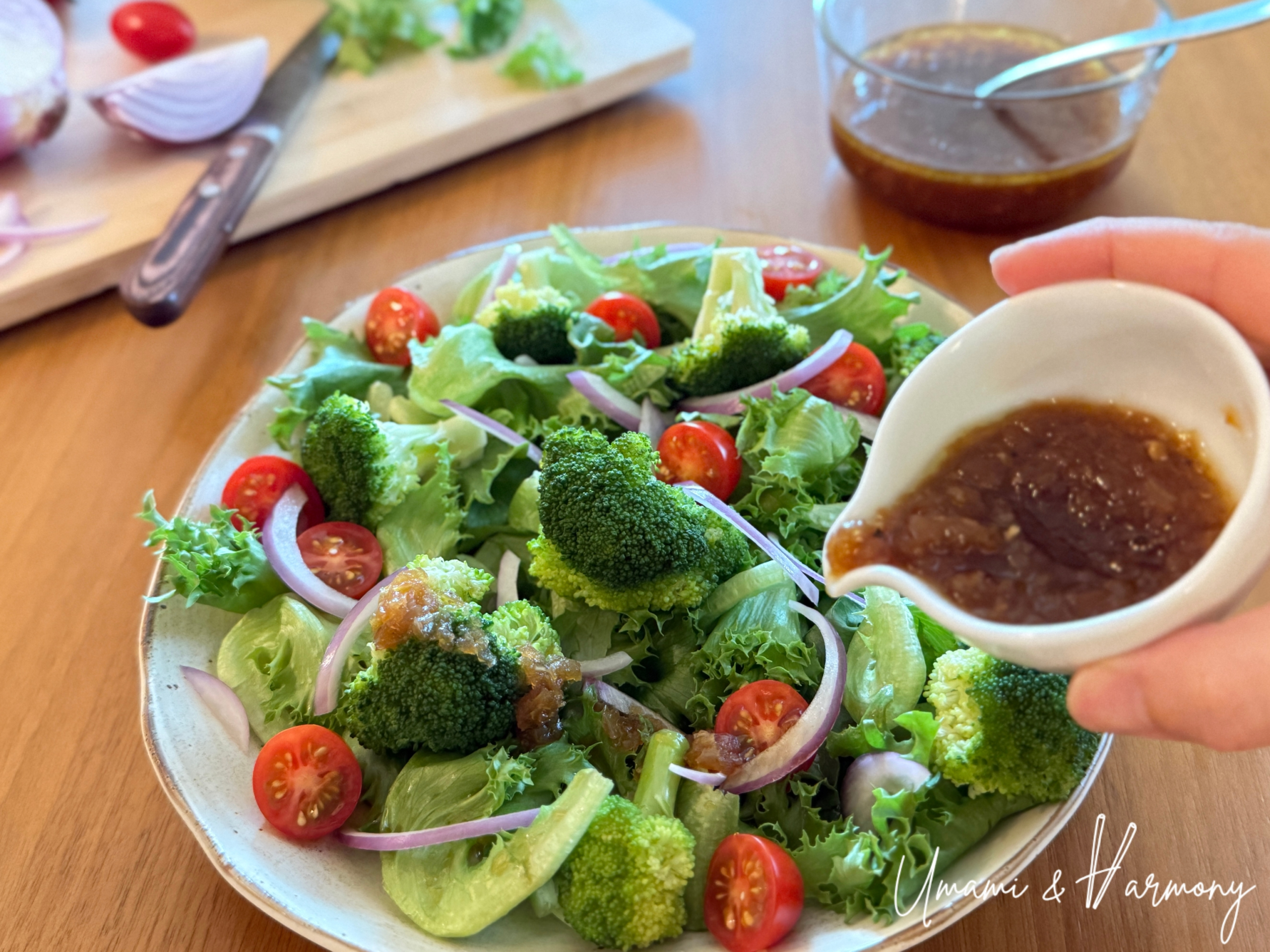 Pouring homemade Japanese onion dressing over a fresh salad