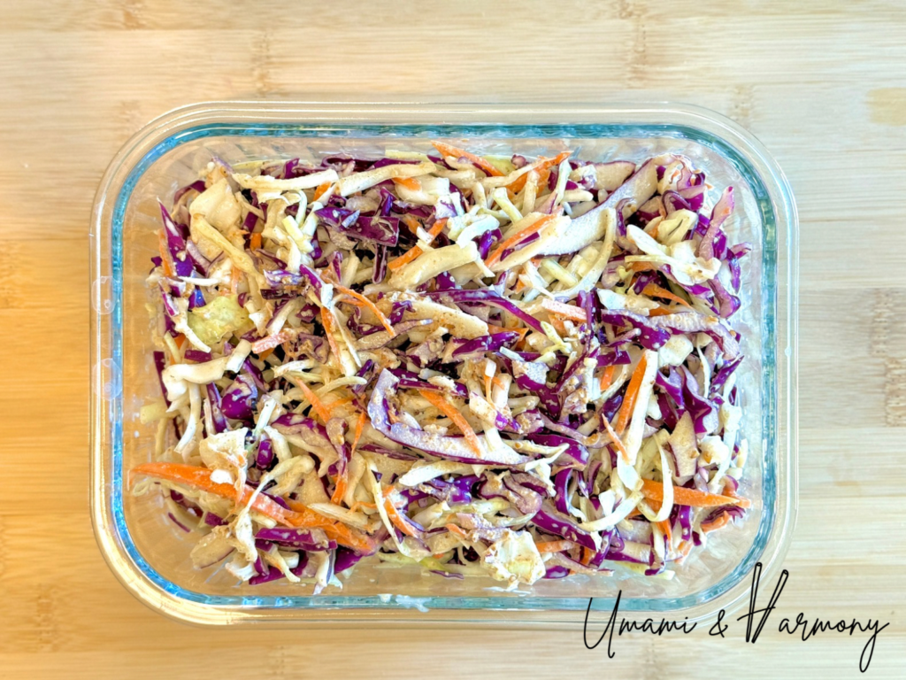 Finished sesame coleslaw stored in a glass container