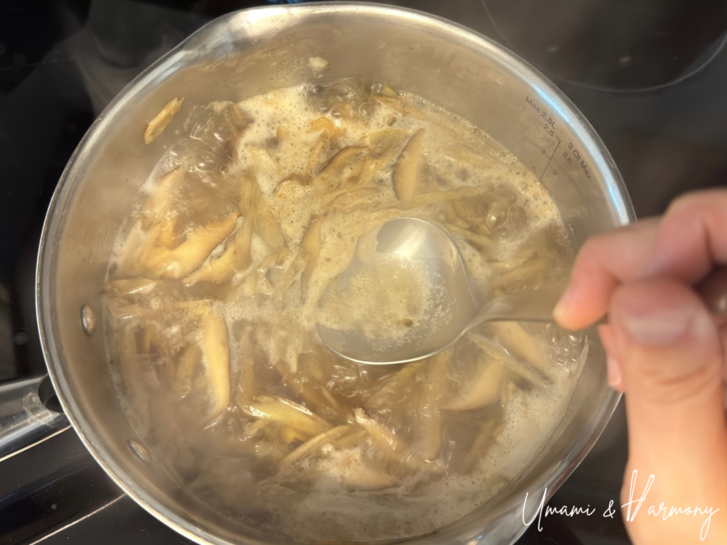 Skimming off foam rising on the surface of the soup