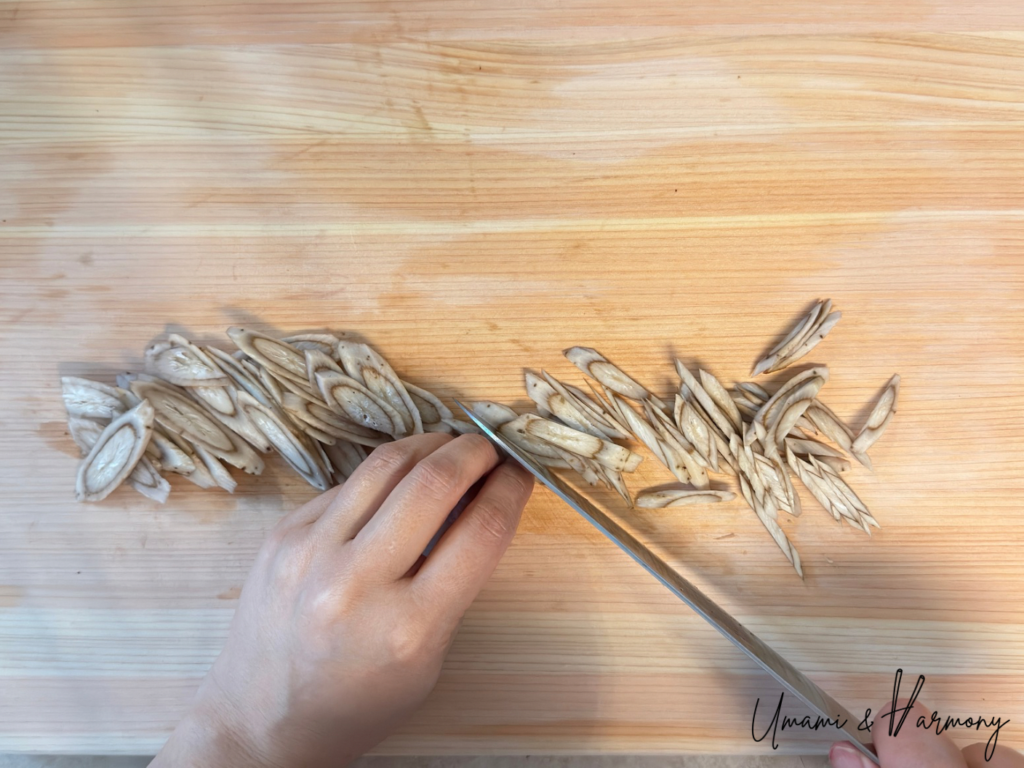Burdock root being sliced into thin pieces