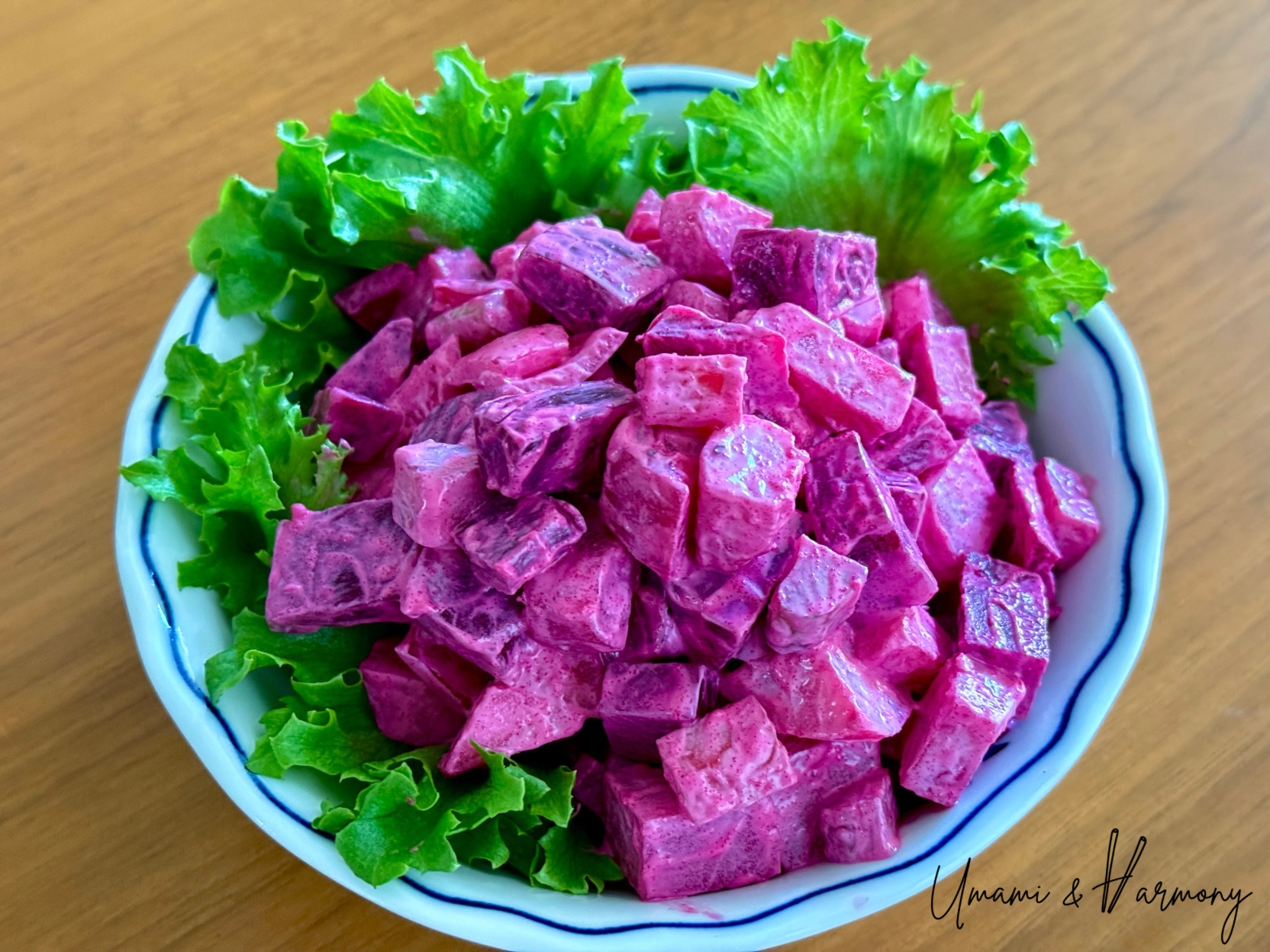 Beet salad served in a bowl with greens on the side