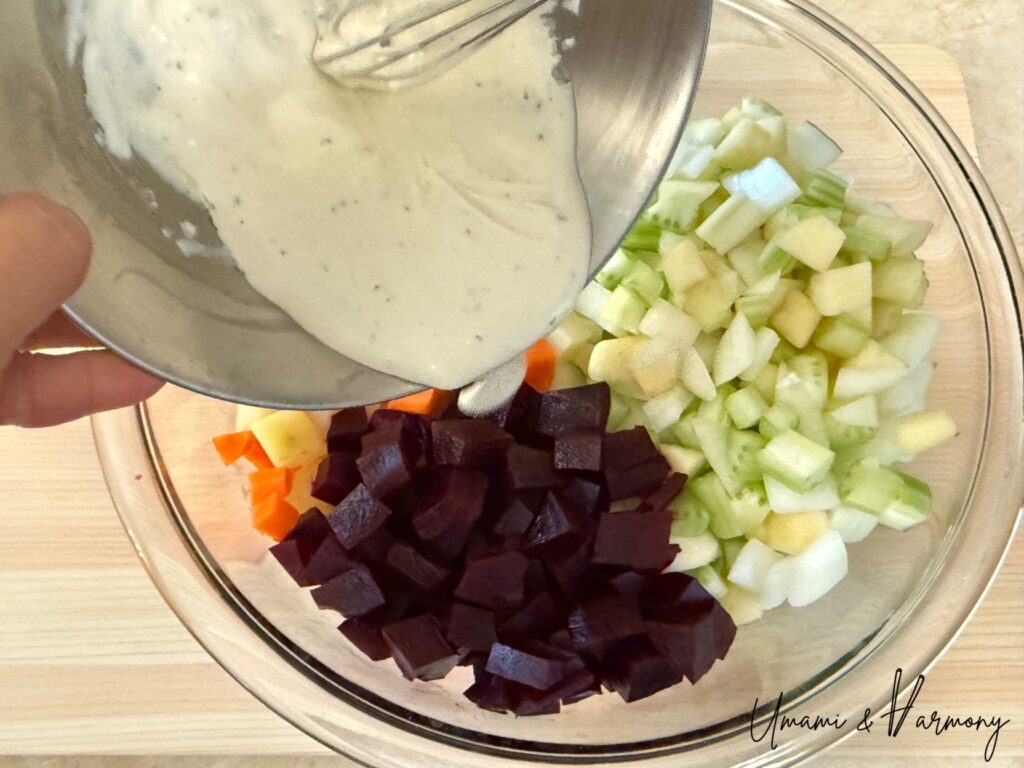 Chopped vegetables in a large bowl with dressing poured over
