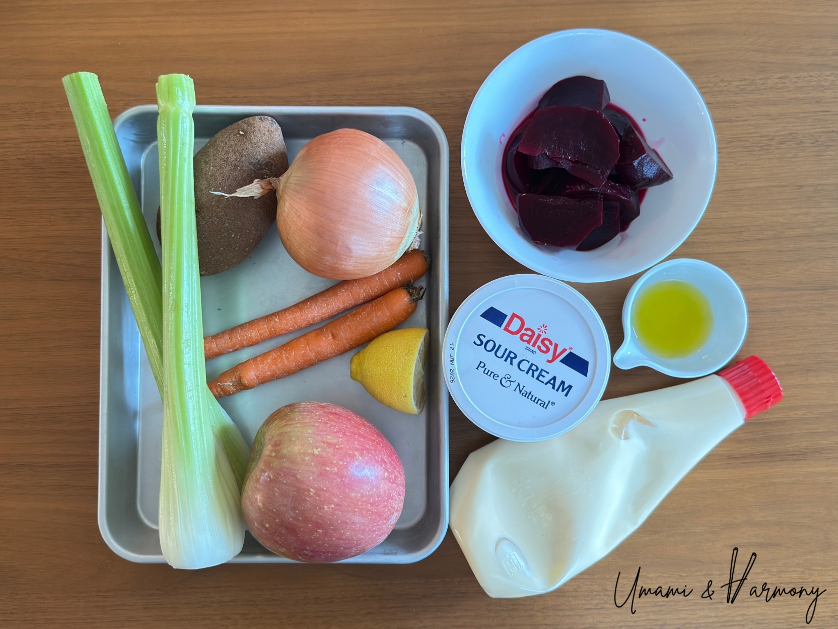 Ingredients for beet salad including vinegar beets, onion, potato, celery, carrots, lemon, Fuji apple, sour cream, olive oil, and mayo