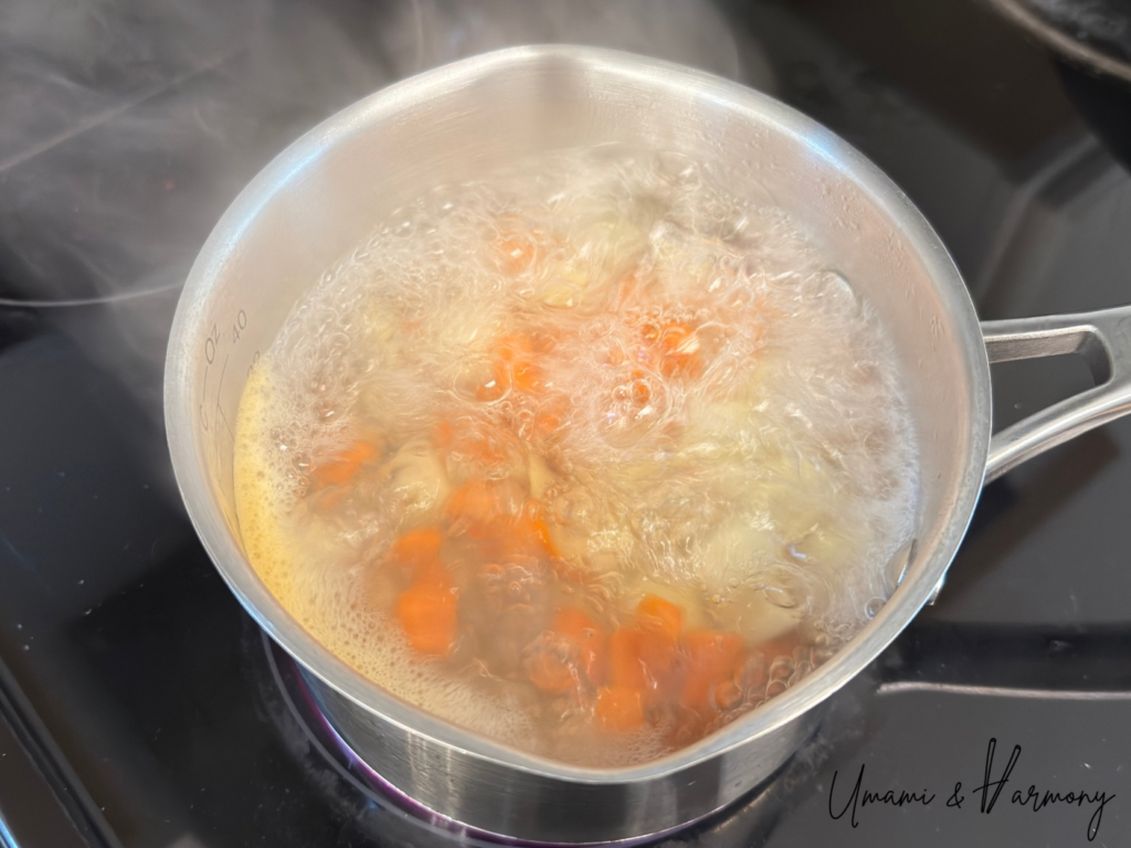 Potatoes and carrots boiling in a pot