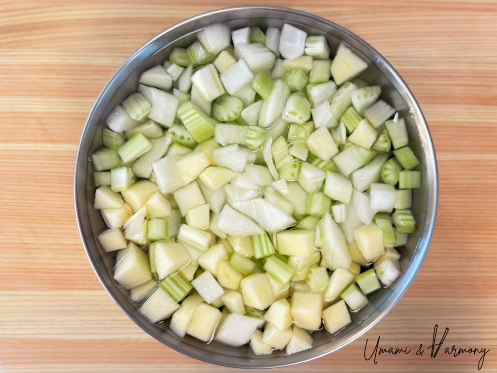Chopped onion, celery, and apple soaking in water