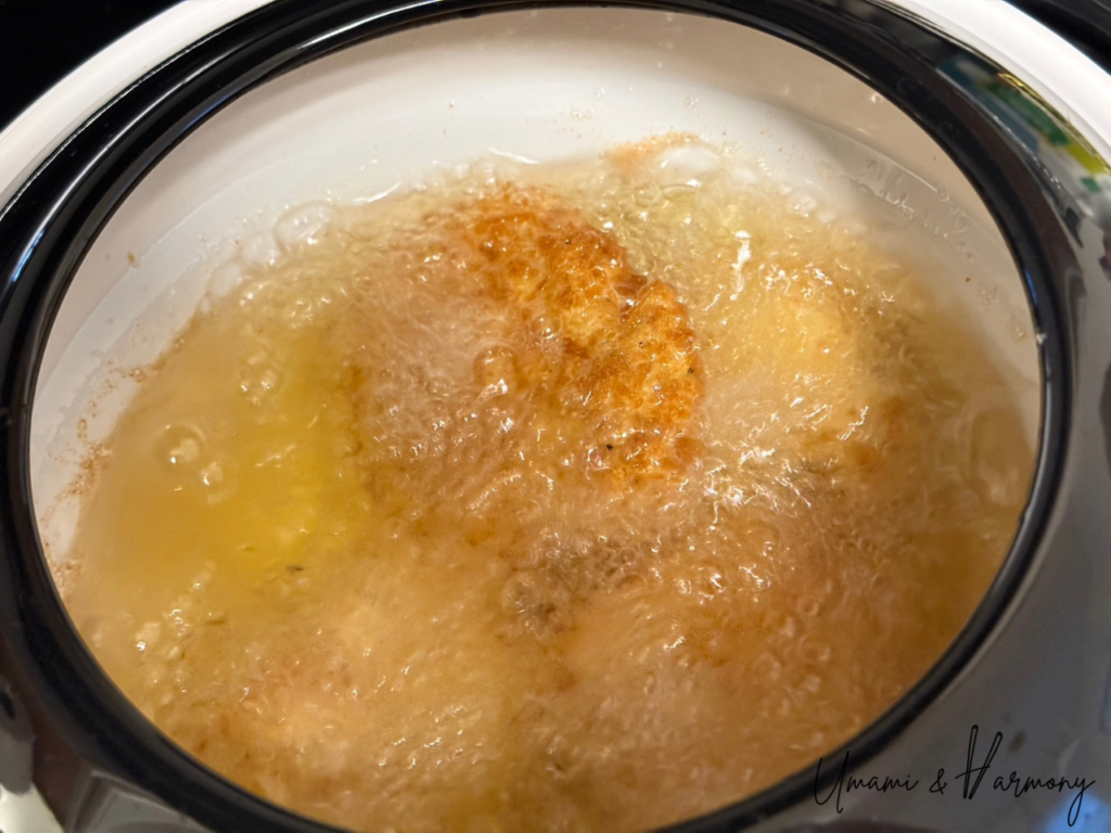 Chicken pieces being deep-fried in hot oil