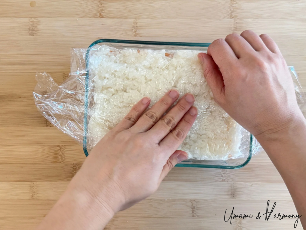 Plastic wrap folded over and sushi pressed gently to shape