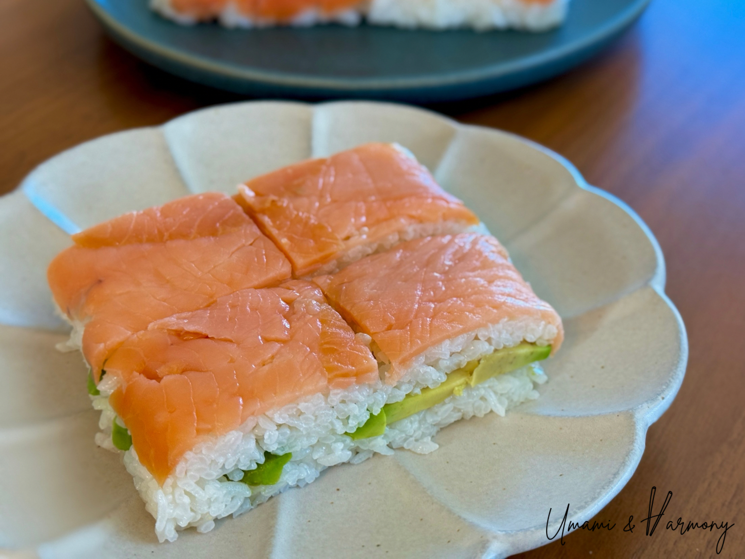 Slices of pressed smoked salmon sushi showing avocado in the middle layer