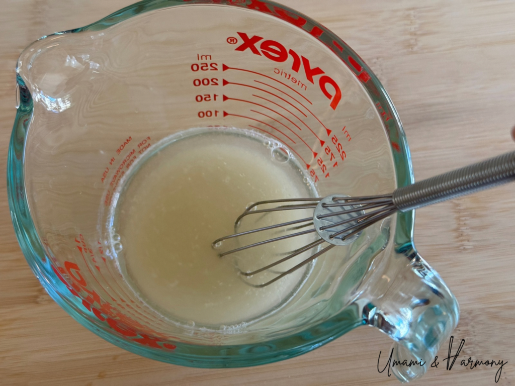 Vinegar mixture being stirred in a measuring cup