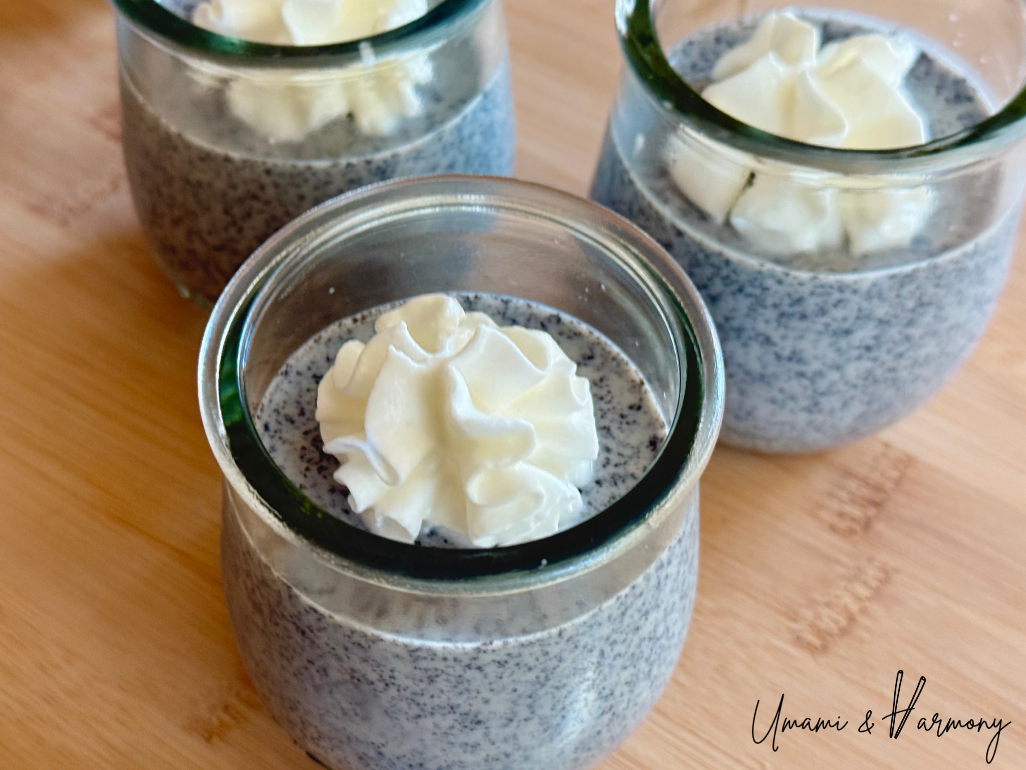 Black sesame pudding topped with whipped cream in a small dessert cup