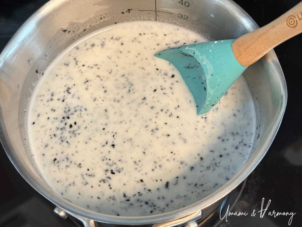 Black sesame paste being mixed into the pudding base