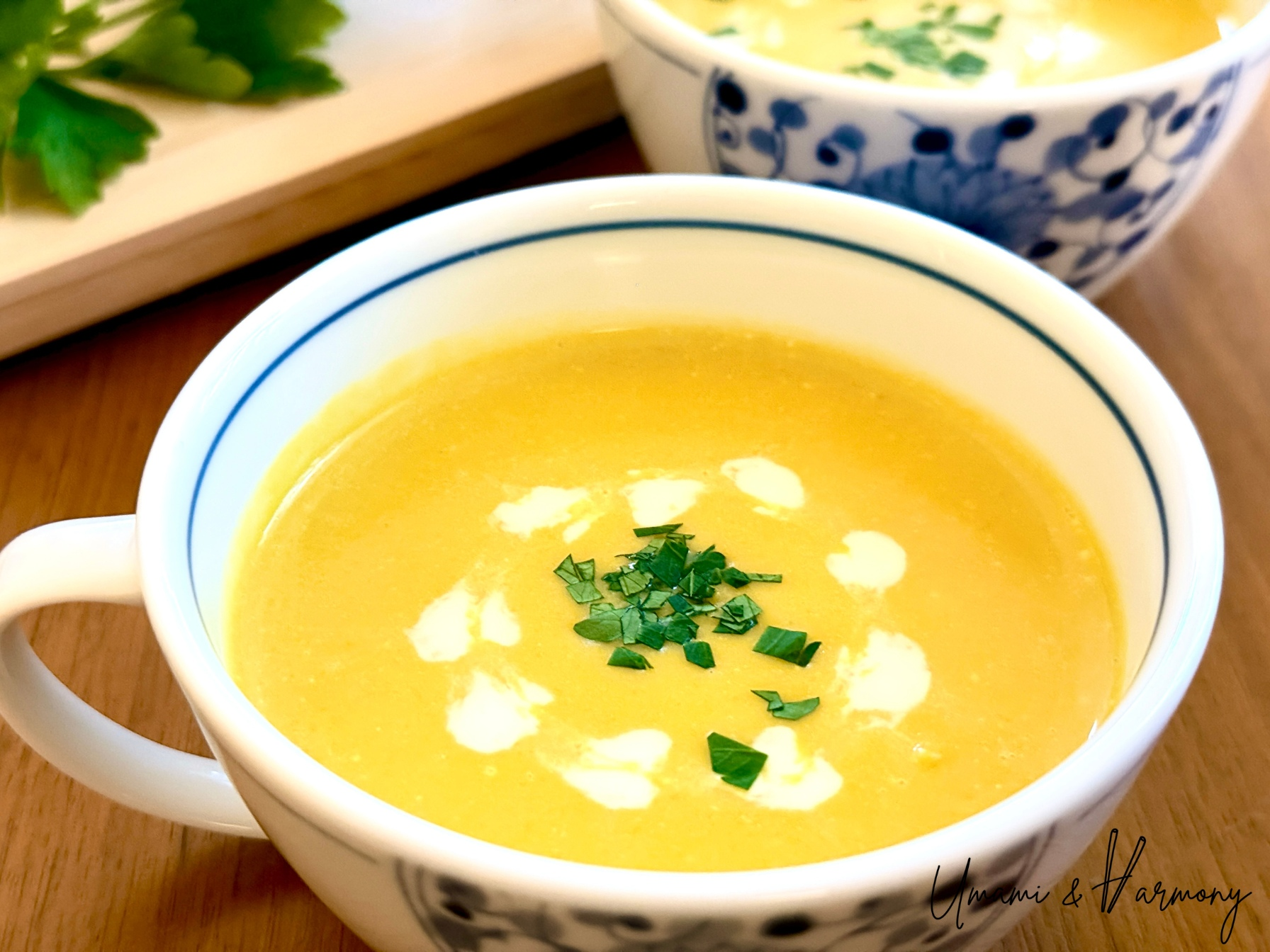 Creamy kabocha squash soup served in a bowl, garnished with parsley